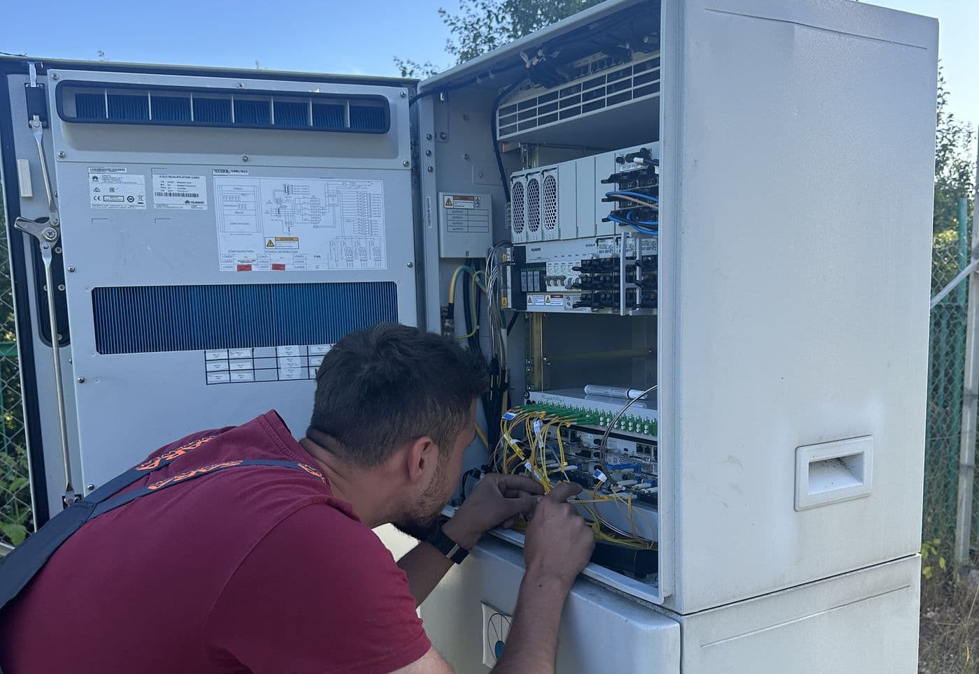 Technik Connects pracuje przy szafie telekomunikacyjnej